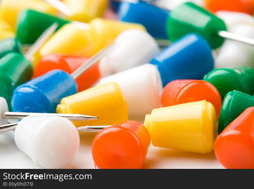 Colored pins on a white background. Close up. Selective focus. Colored pins on a white background. Close up. Selective focus.