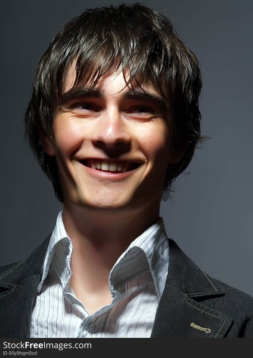 A portrait about a trendy handsome young man who is smiling. He is wearing a white shirt and a black suit. A portrait about a trendy handsome young man who is smiling. He is wearing a white shirt and a black suit.