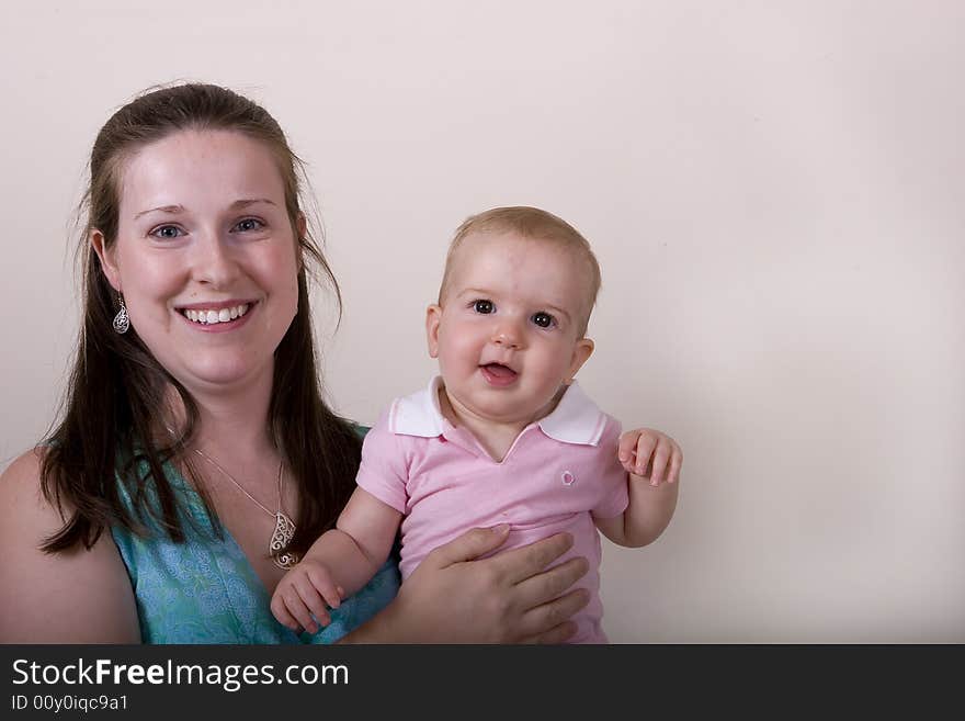 A smiling young woman with her infant daughter. A smiling young woman with her infant daughter