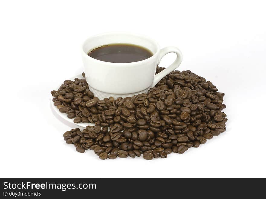 A black cup of coffee sitting on a saucer surrounded by roasted columbian coffee beans. A black cup of coffee sitting on a saucer surrounded by roasted columbian coffee beans.