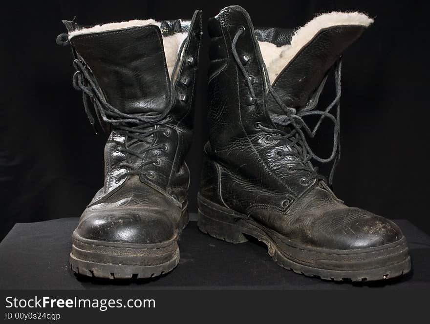 A pair of black thicket boots on a black background. A pair of black thicket boots on a black background