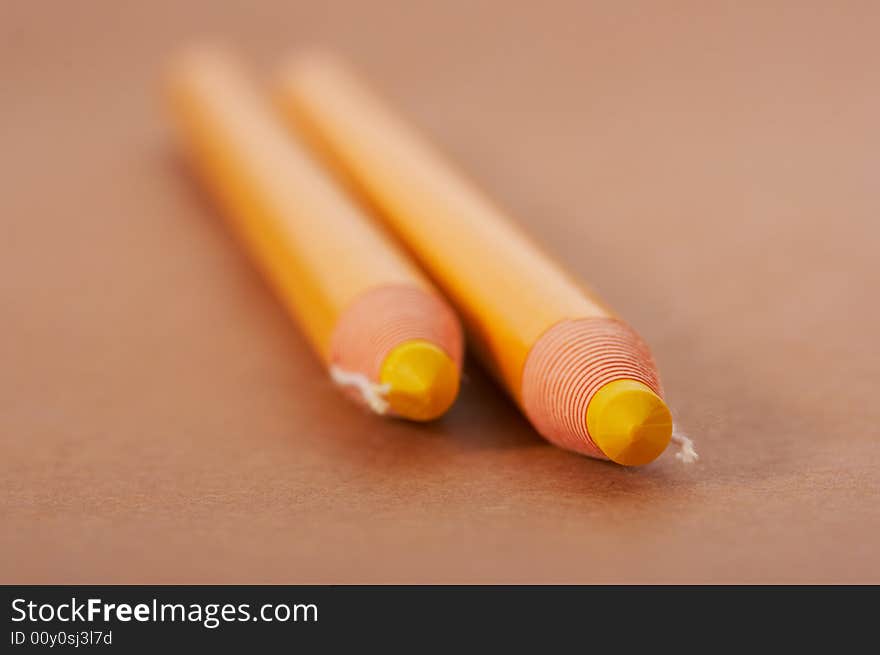 Yellow pencils on a brown paper background