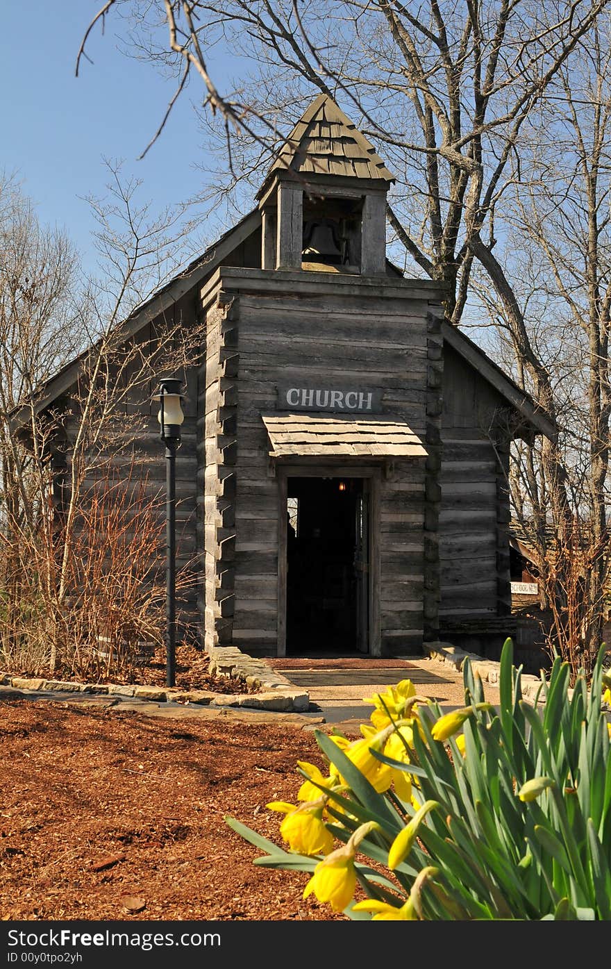 Olr rural wooden church with flowers on a sunny day. Olr rural wooden church with flowers on a sunny day