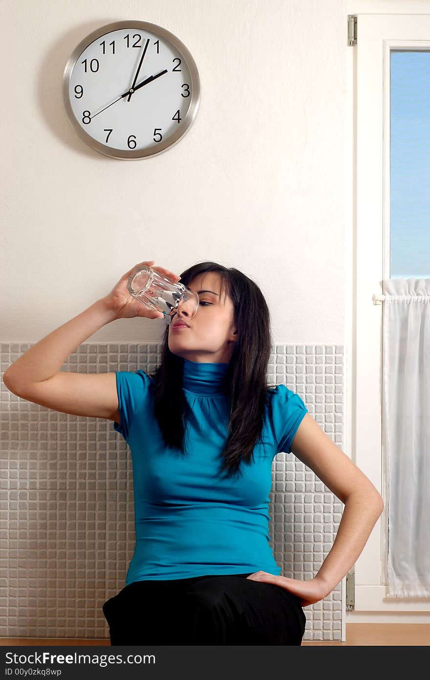 A pretty young woman lifting a glass of water. A pretty young woman lifting a glass of water