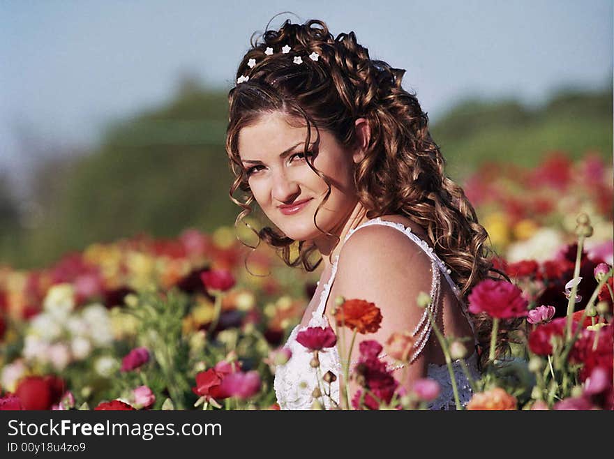 Bride sitting in flowers field