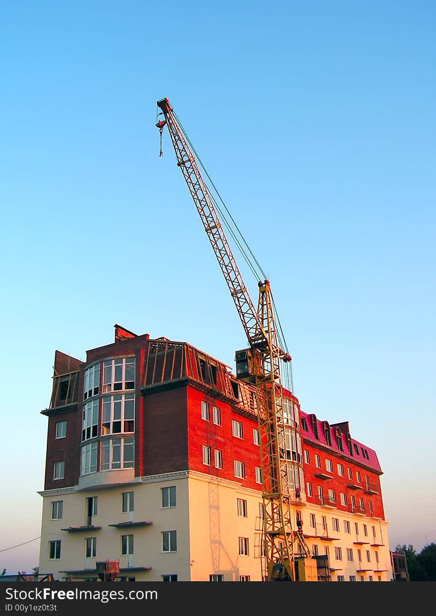 The building crane stands near a builded house