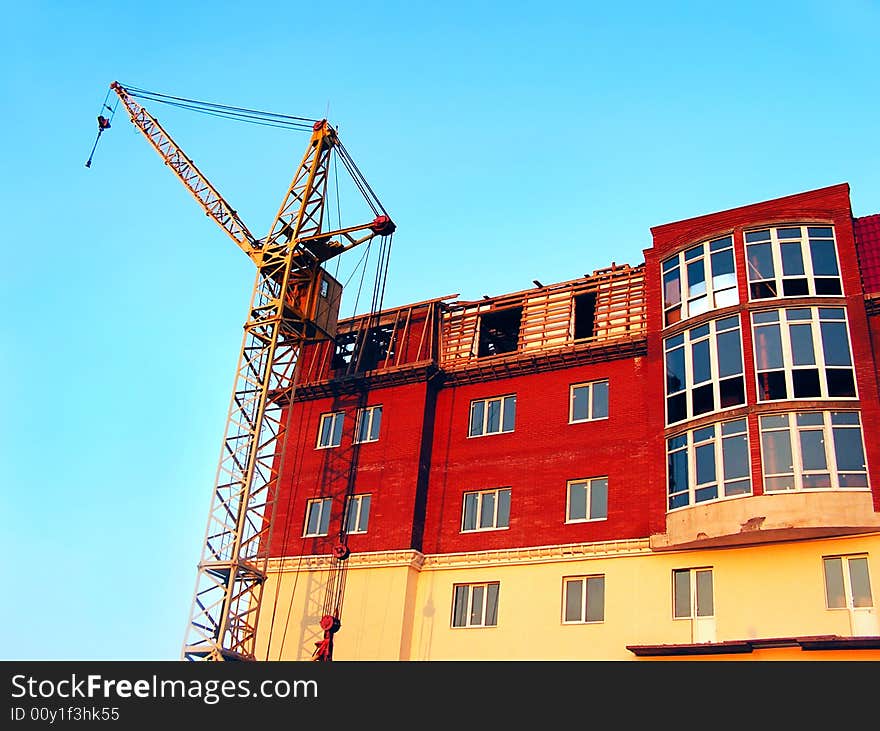 The building crane stands near a builded house