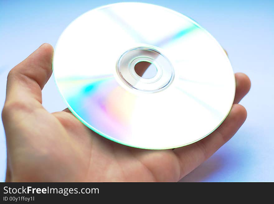 A hand handing over a CD or DVD with white background. A hand handing over a CD or DVD with white background.