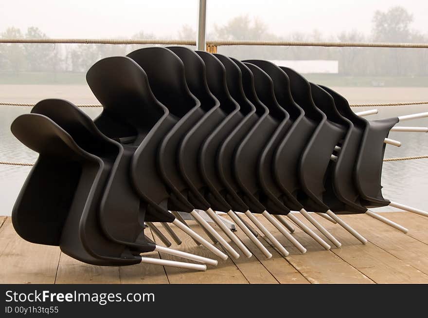 Stacked black chairs in line. Stacked black chairs in line