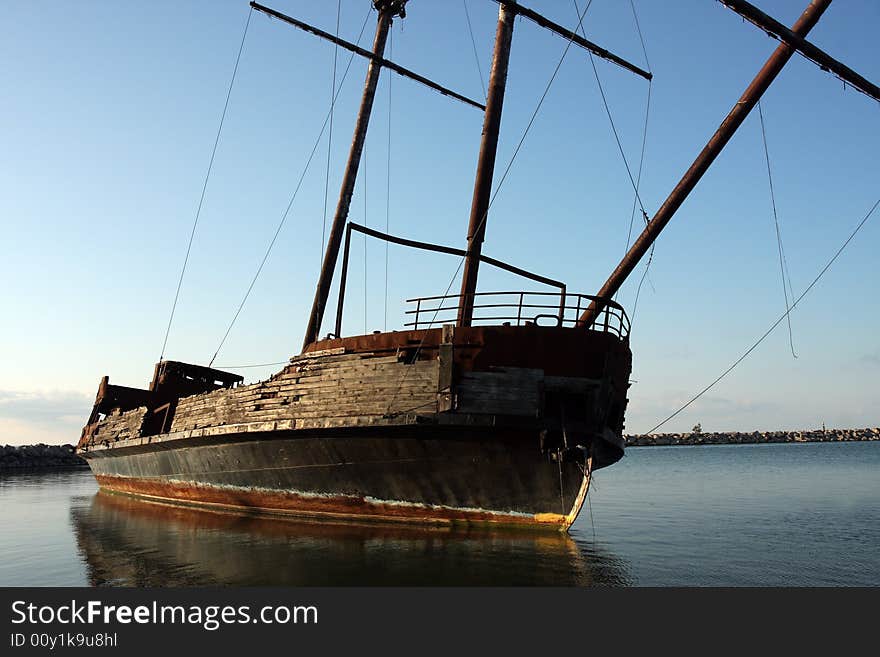 An old and weathered boat's final resting place in the water.