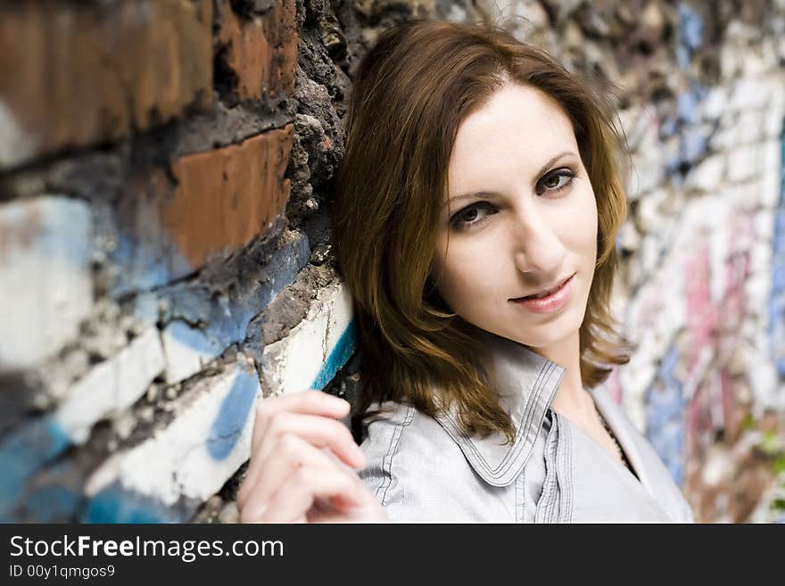 Model woman leaning against a concrete wall