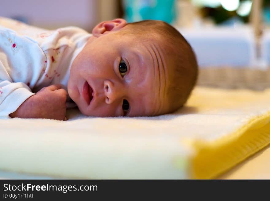 Three week baby lying on his belly looking straight into camera. Three week baby lying on his belly looking straight into camera