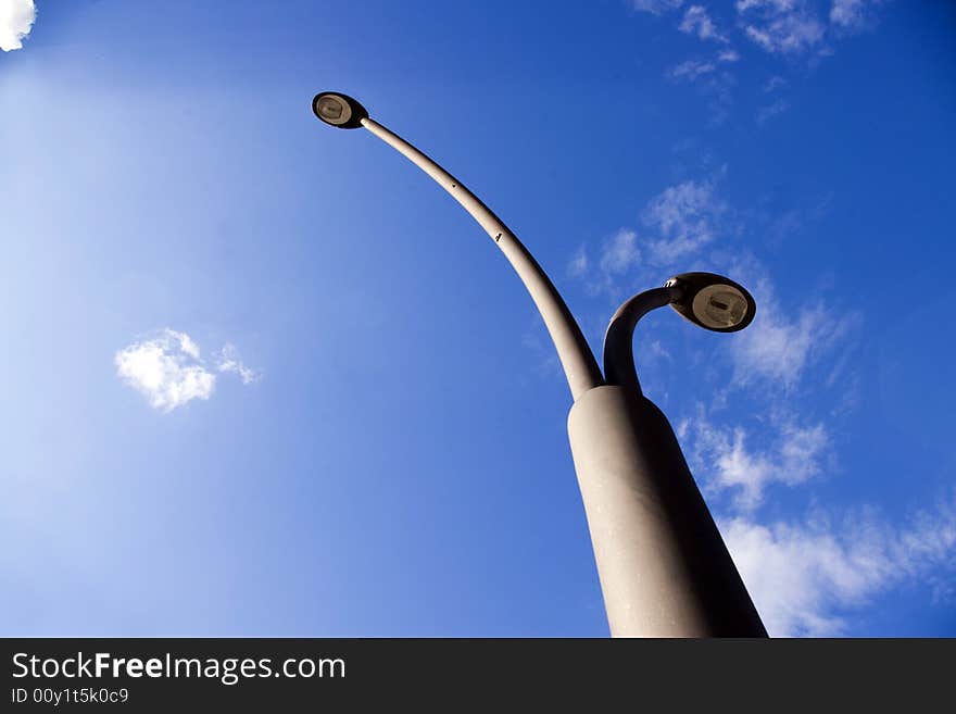 Street lamps towards blue sky. Street lamps towards blue sky