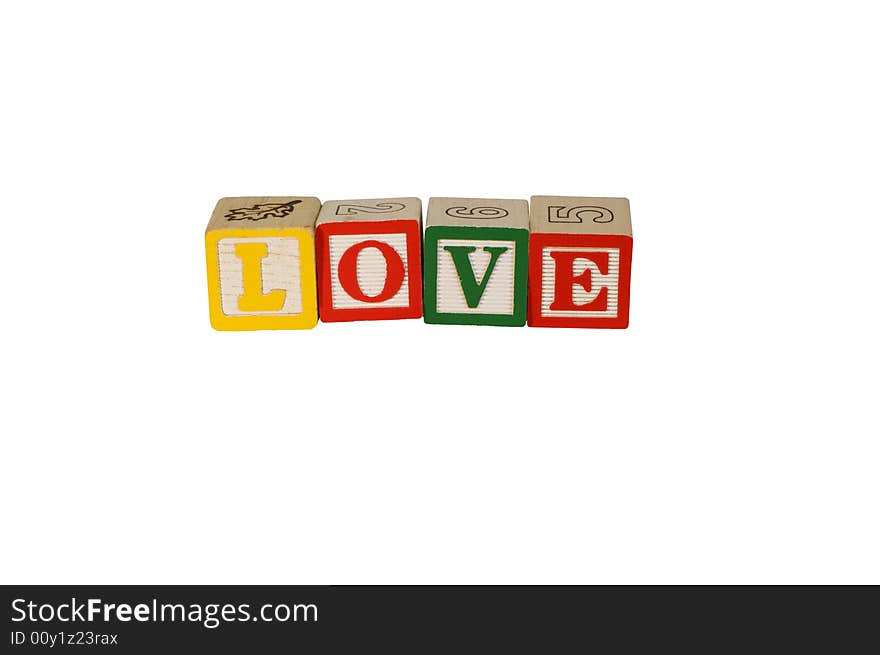 Toy wooden blocks spelling LOVE with yellow, red, and green