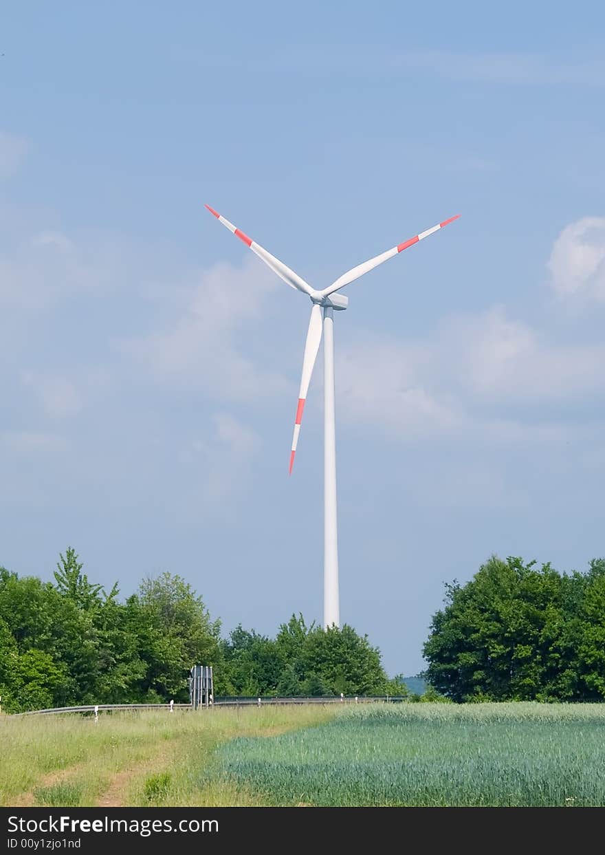 Windmill with green field and blue sky background. Windmill with green field and blue sky background