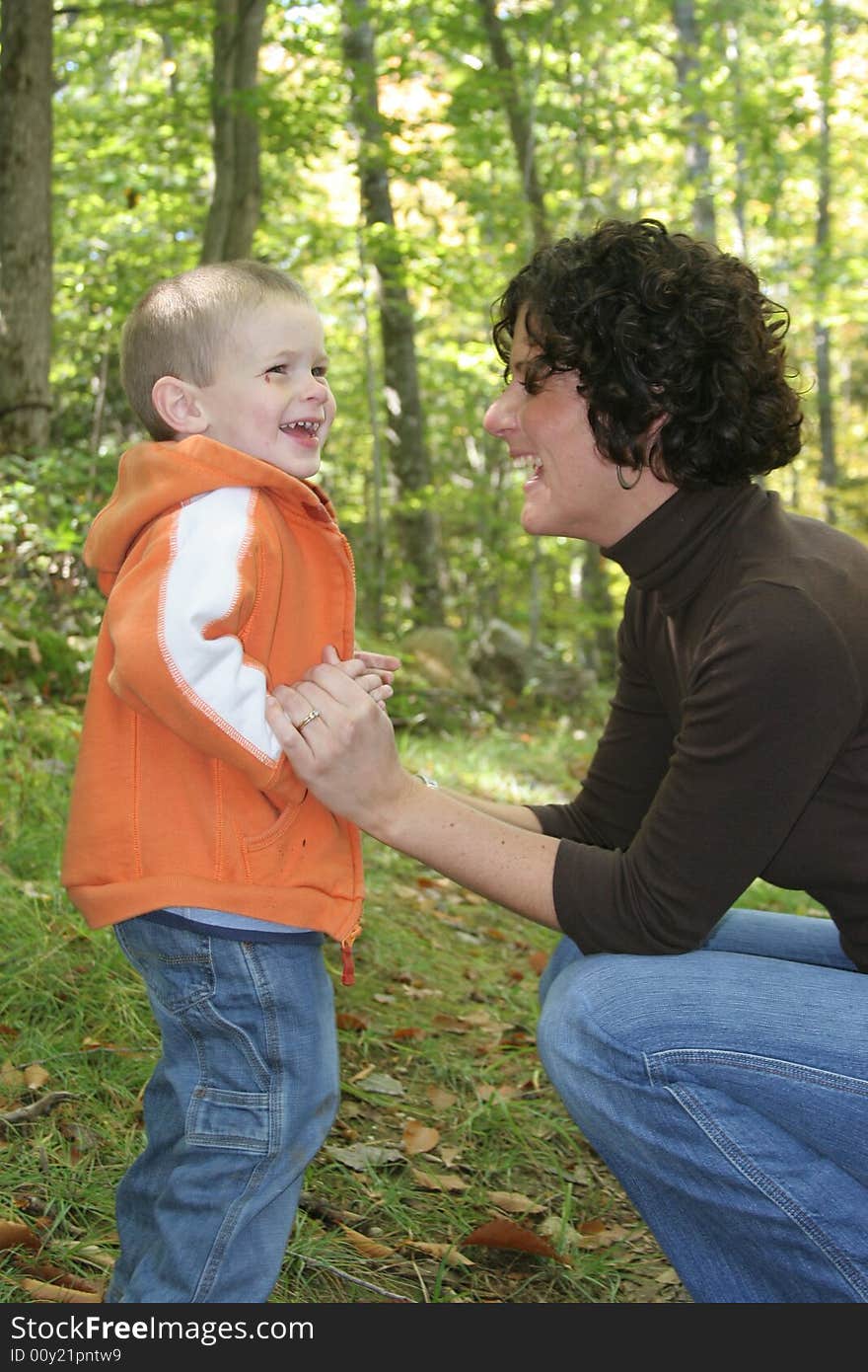 Mother and son laughing as they go for a quality walk in the woods together.