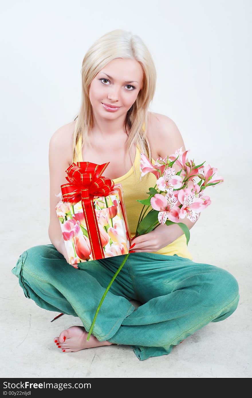 Smiling blond dressed in yellow shirt with big gift box in hands. Smiling blond dressed in yellow shirt with big gift box in hands