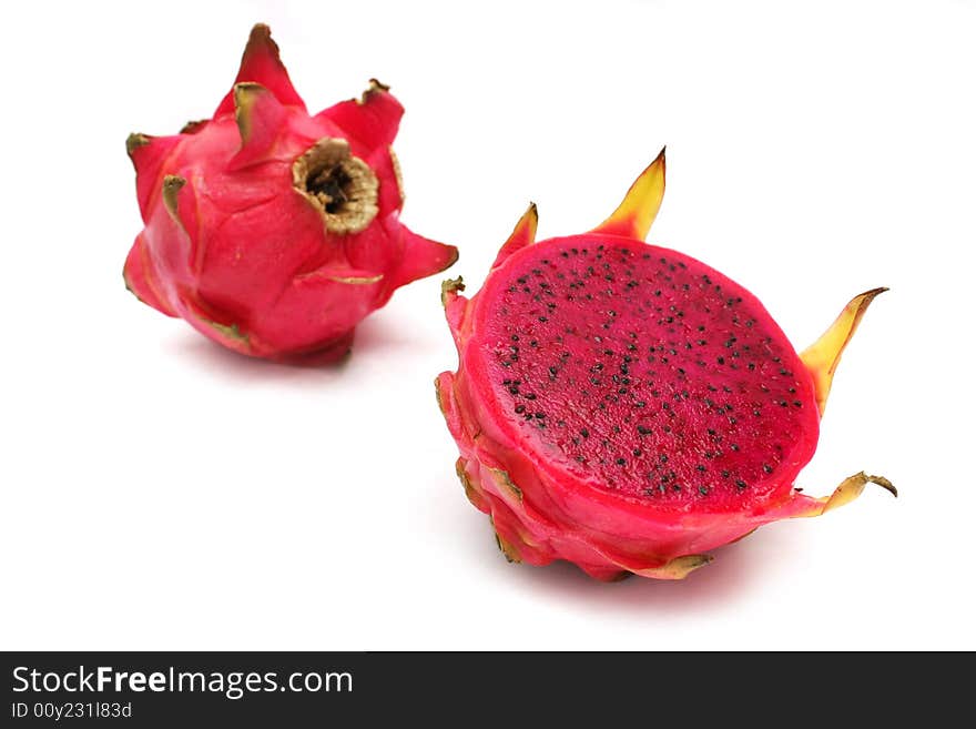 An half and full red dragon fruits over white background.