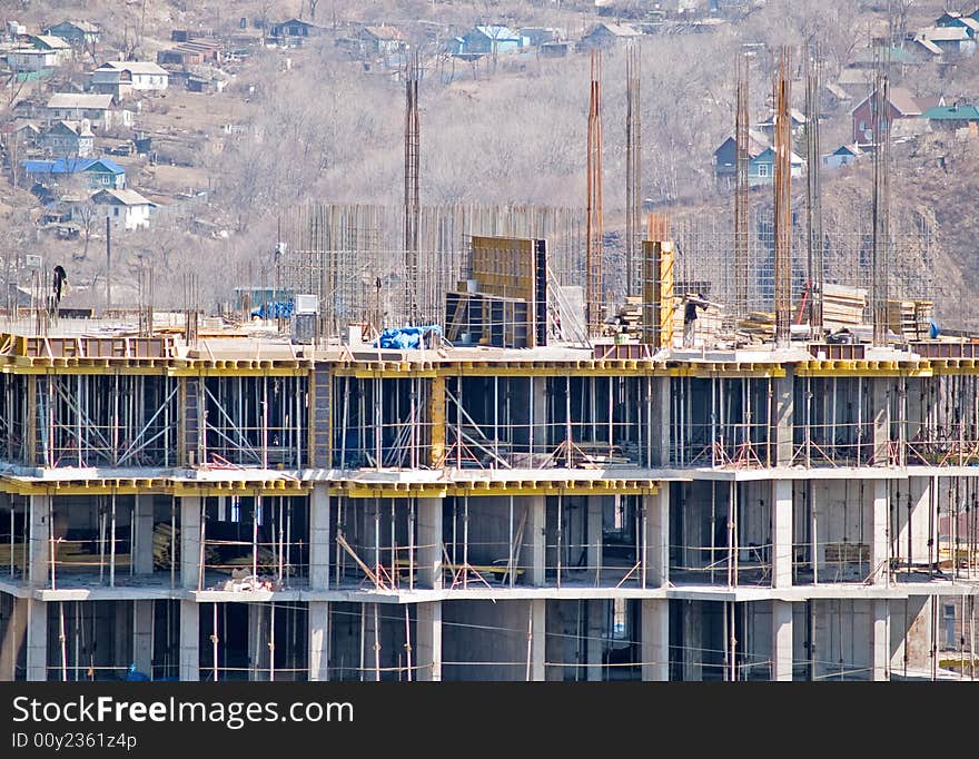 Modern monolith housebuilding yard against the old town. Modern monolith housebuilding yard against the old town