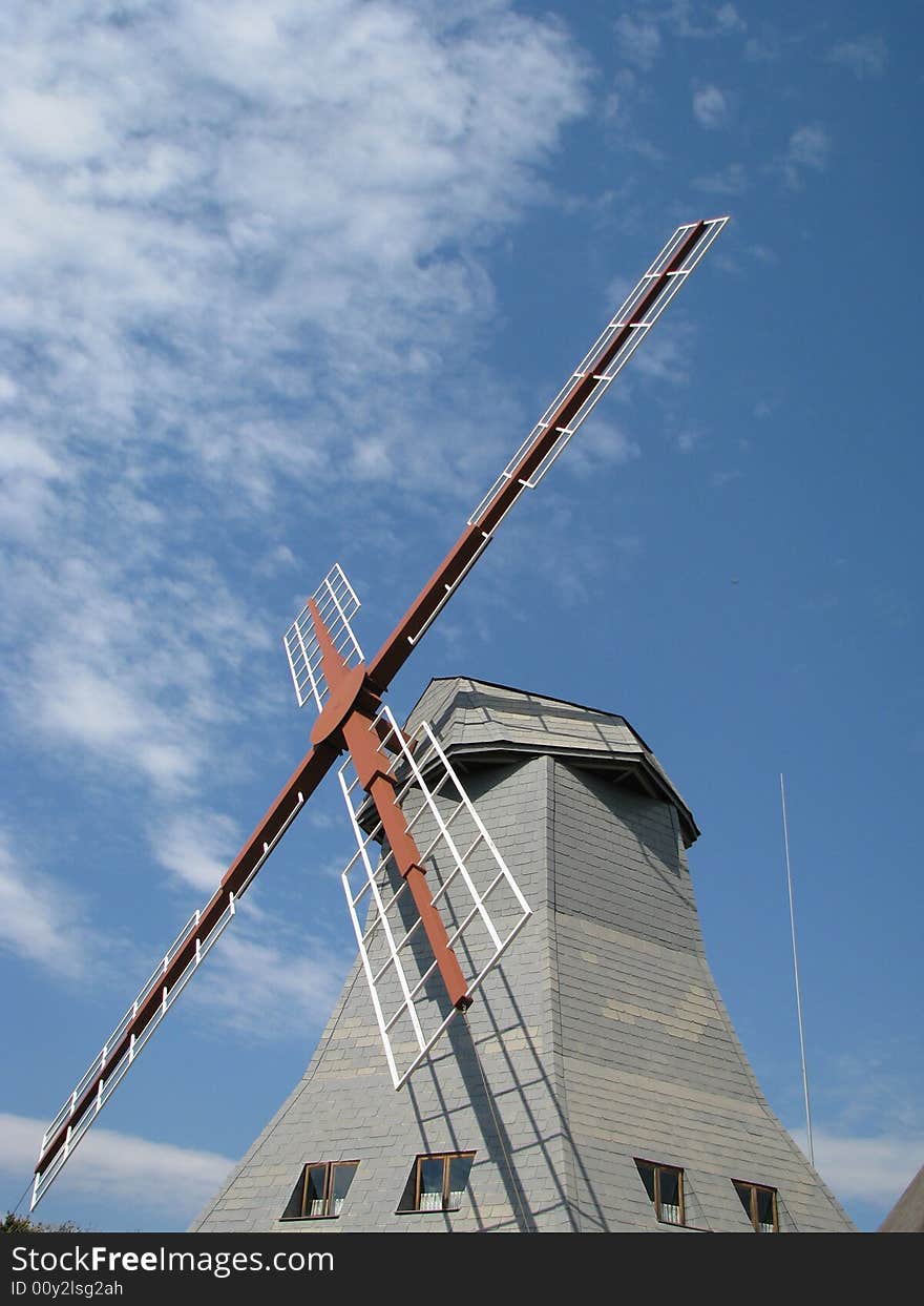 Windmill arm stretching out into a cloud spattered sky. Windmill arm stretching out into a cloud spattered sky.