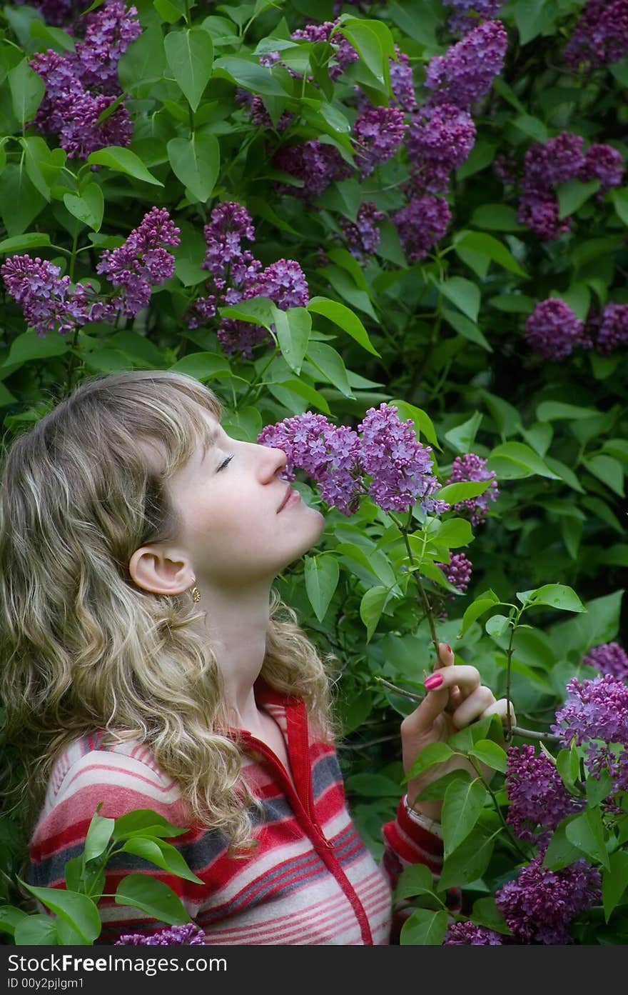 The girl smells a lilac