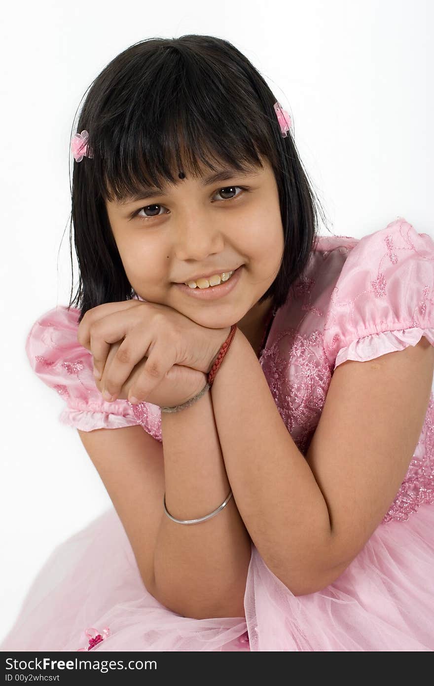 Young Asian girl in pink dress striking a pose for camera. Young Asian girl in pink dress striking a pose for camera