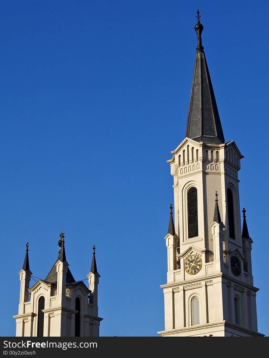 A pair of ornate steeples set against a cloudless blue sky,. A pair of ornate steeples set against a cloudless blue sky,