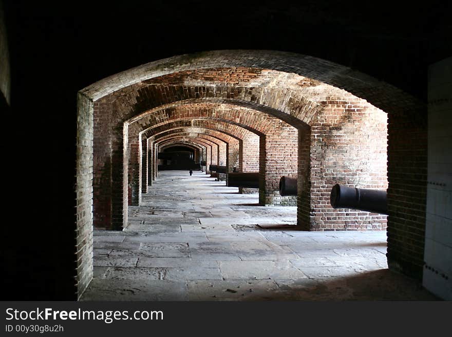 A brick arch way with daylight shinny through.