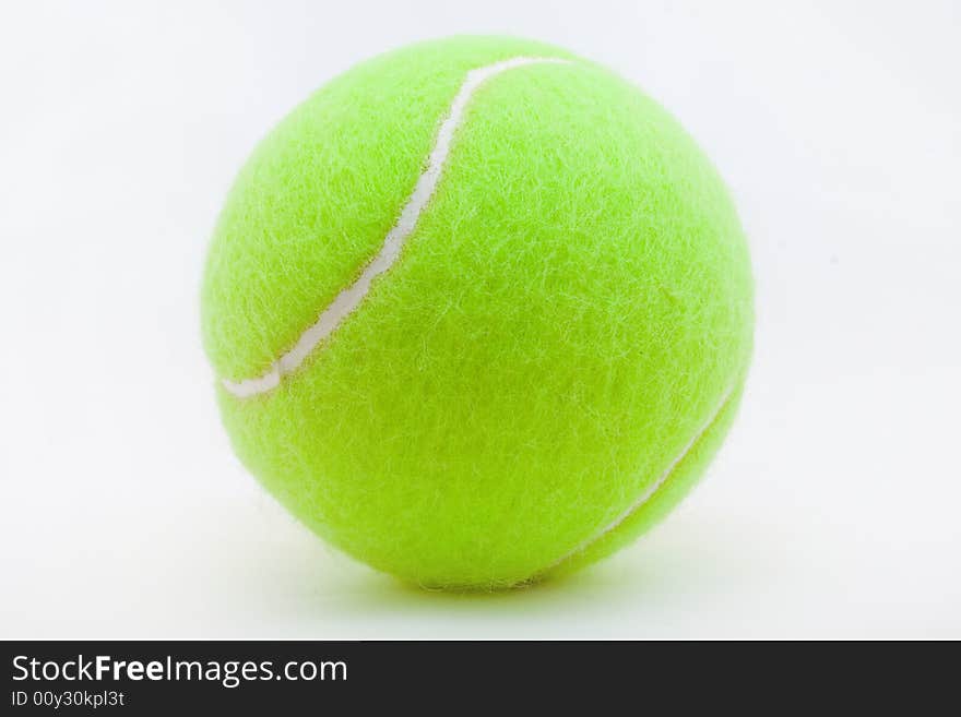 Green tennis ball laying on a white background