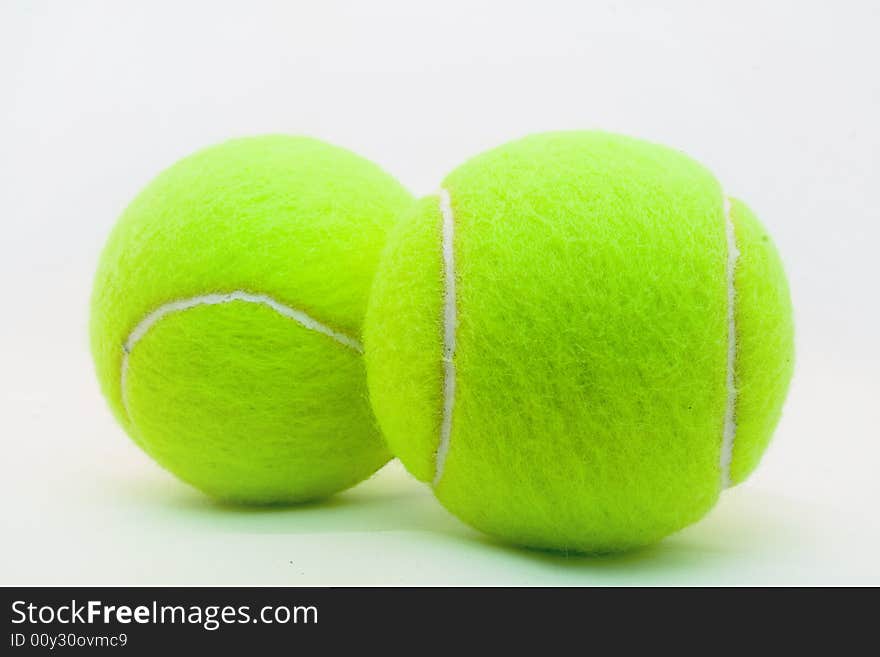 Green tennis ball laying on a white background