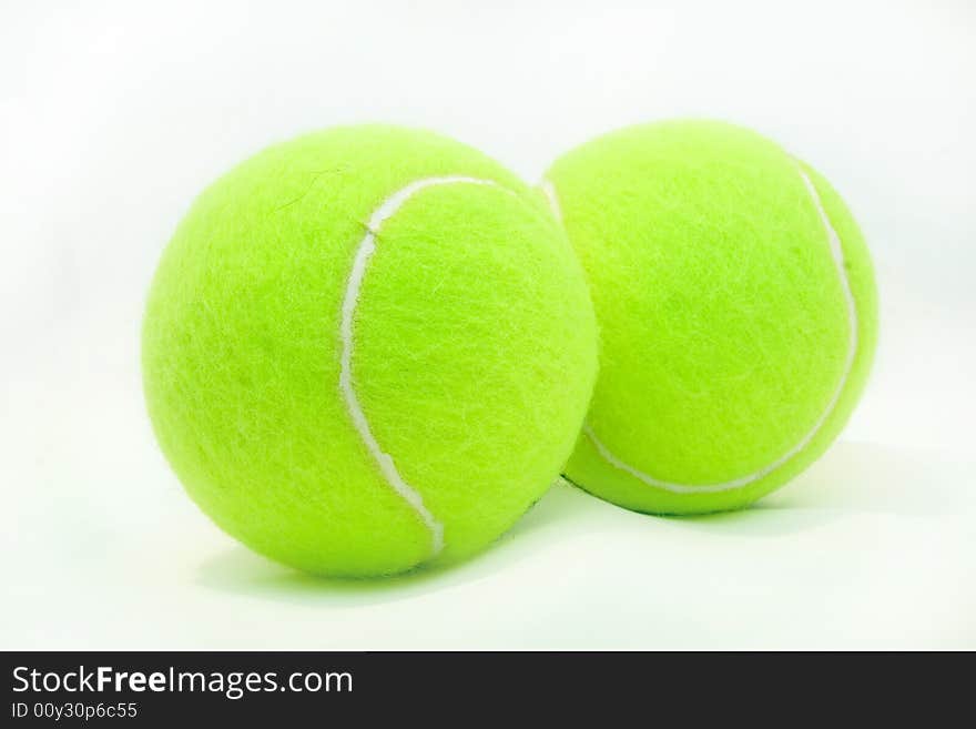 Green tennis ball laying on a white background