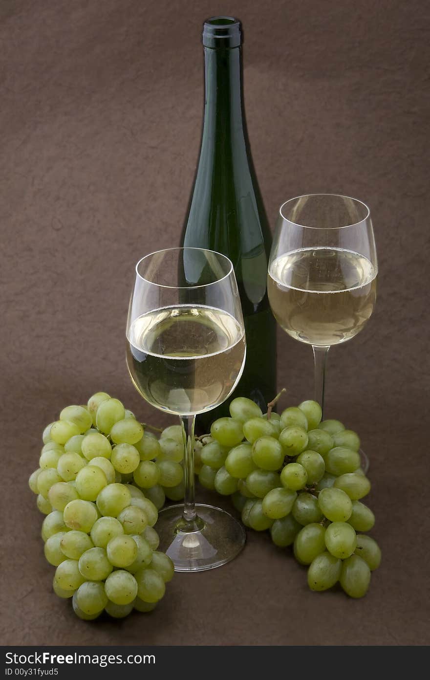 White wine with bottle, glasses and grapes against a background