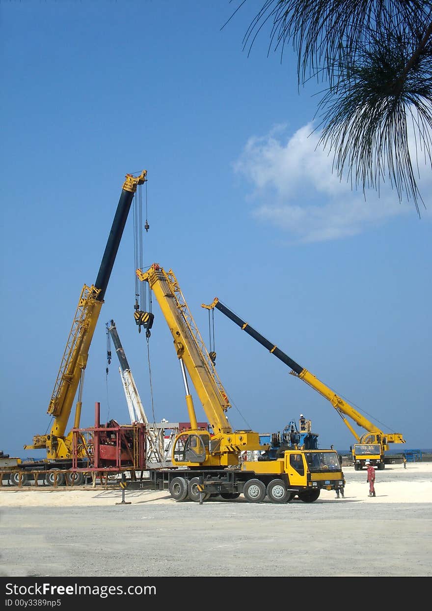 Four cranes truck working at an oil plant. Four cranes truck working at an oil plant