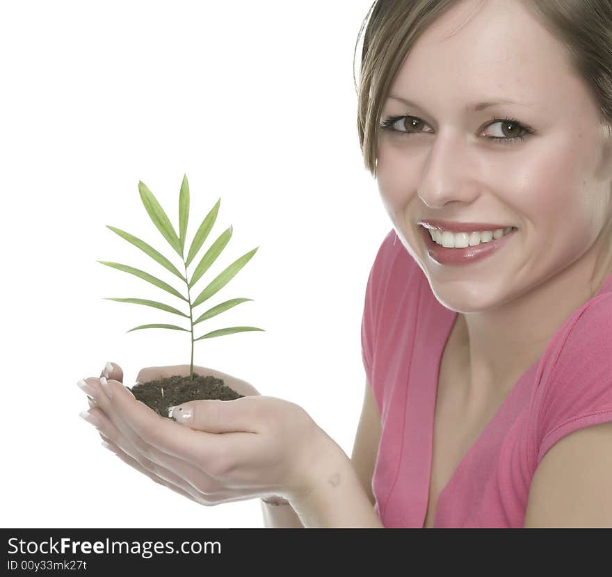 A pretty young woman holding a growing plant. A pretty young woman holding a growing plant