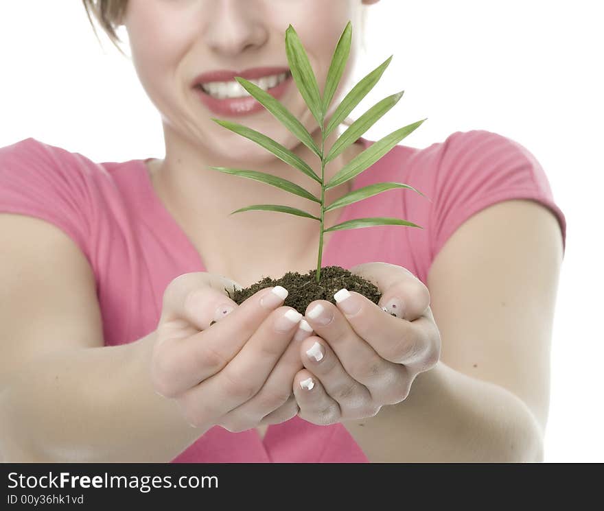 A pretty young woman holding a growing plant. A pretty young woman holding a growing plant