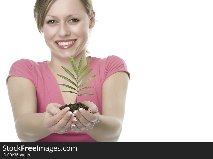 A pretty young woman holding a growing plant. A pretty young woman holding a growing plant