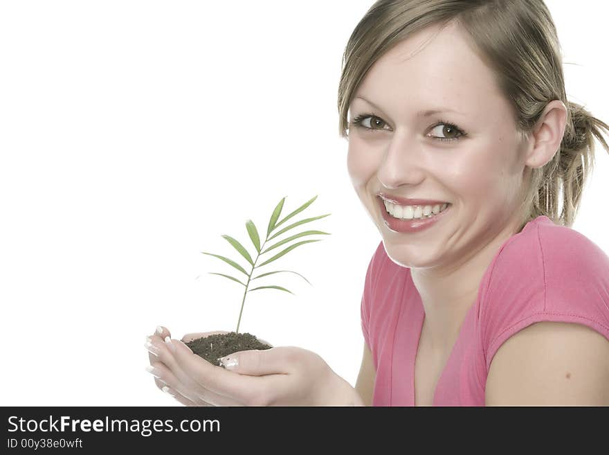 A pretty young woman holding a growing plant. A pretty young woman holding a growing plant