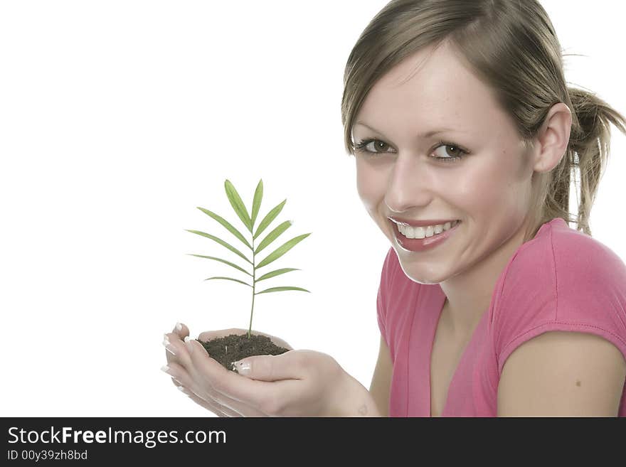 A pretty young woman holding a growing plant. A pretty young woman holding a growing plant