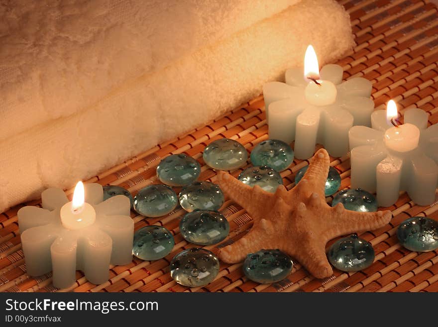 Bath towels, candles, starfish and glass pebbles. Bath towels, candles, starfish and glass pebbles