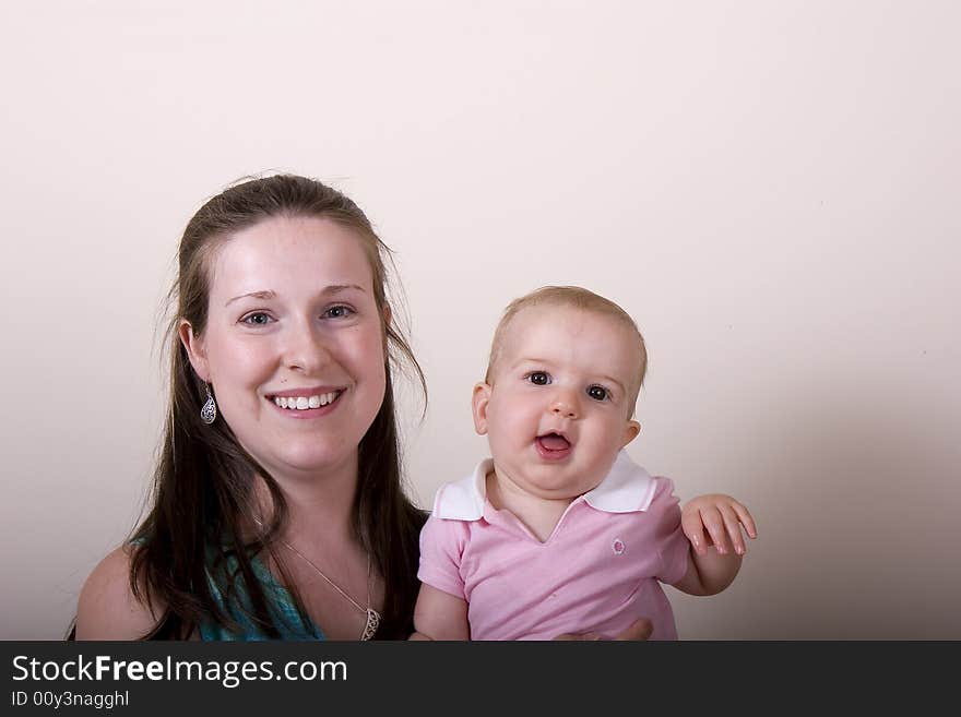 A young woman with a baby waving at the camera. A young woman with a baby waving at the camera