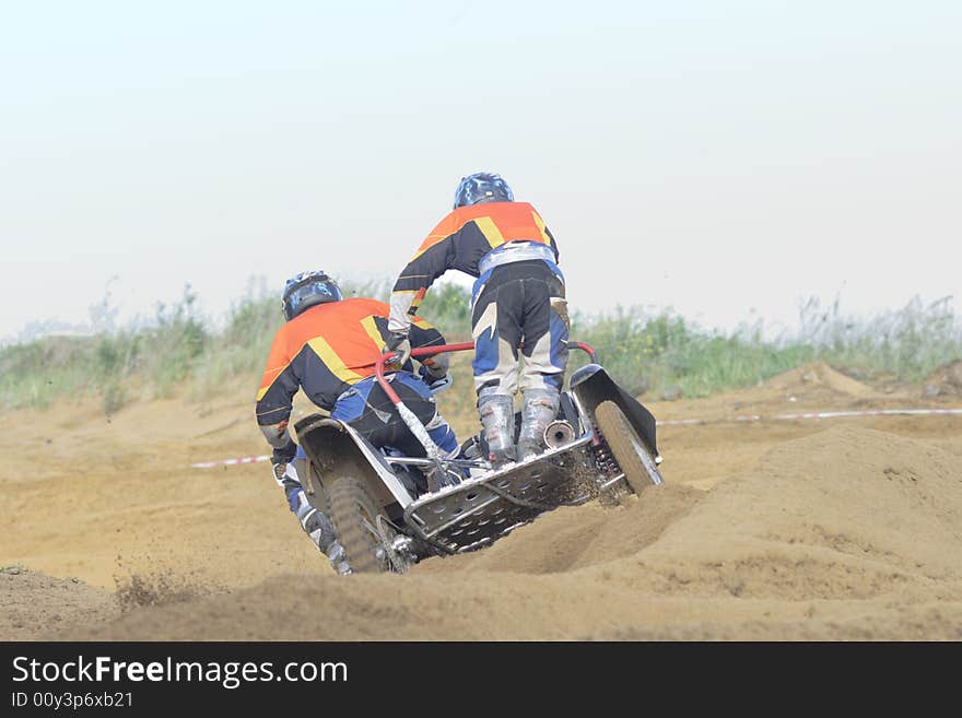 Two motorcyclists aspire to finish on sandy road. Two motorcyclists aspire to finish on sandy road