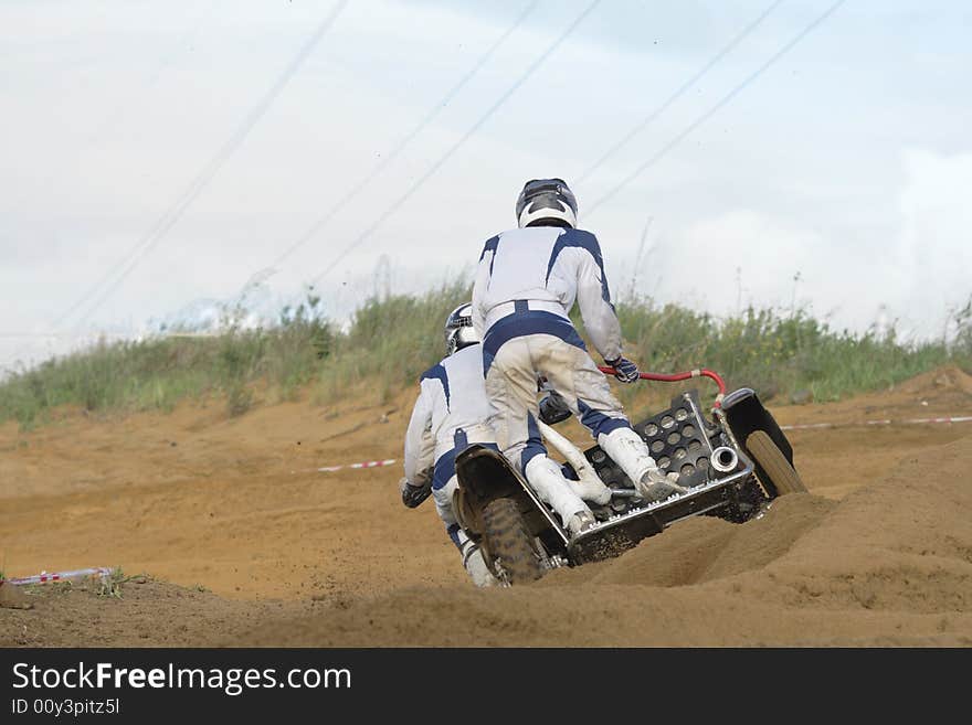 Two motorcyclists aspire to finish on sandy road. Two motorcyclists aspire to finish on sandy road