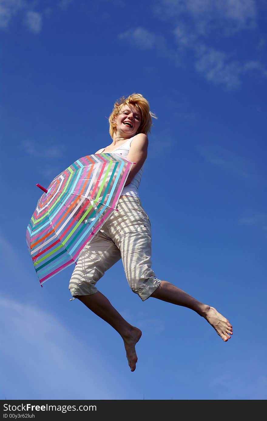 Young charming girl with umbrella against blue sky