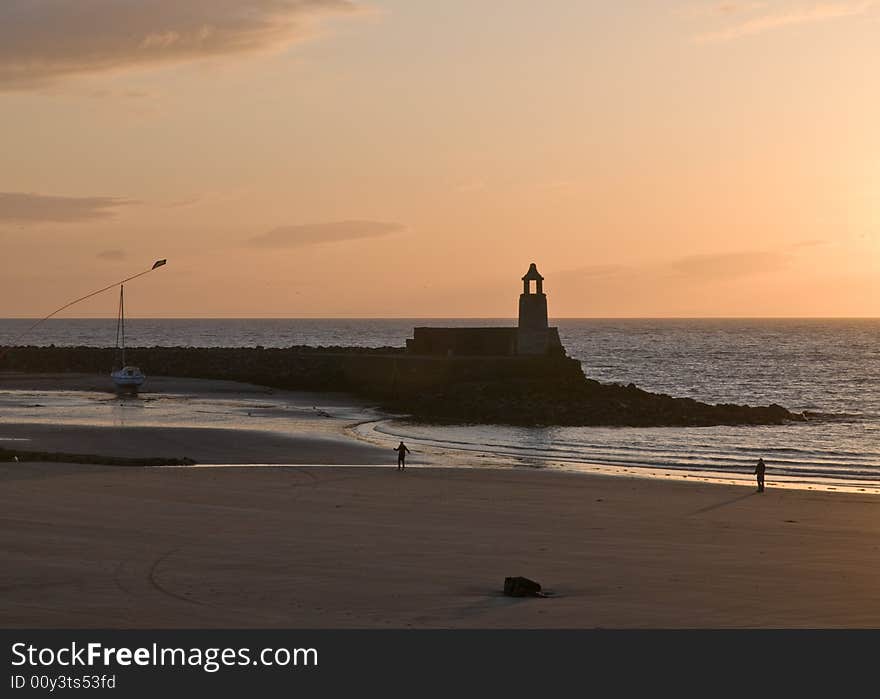 A lighthouse on the beach as sunsets