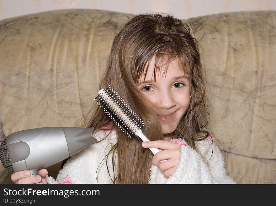 The little girl dries hair after bathing. The little girl dries hair after bathing