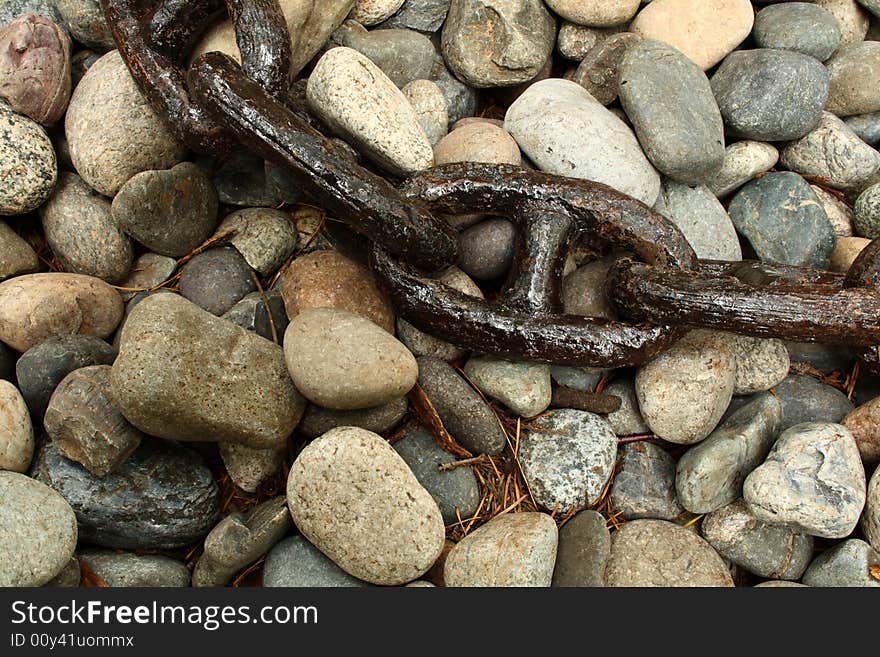 Close up on an old and rusty chain over a stone surface