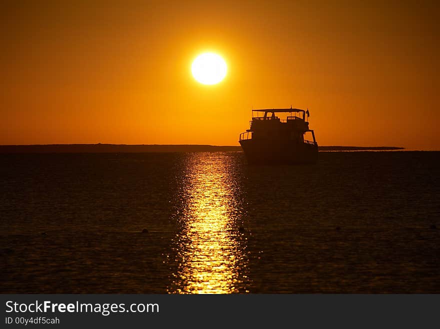 Boat silhouette and golden sunrise over the ocean. Boat silhouette and golden sunrise over the ocean