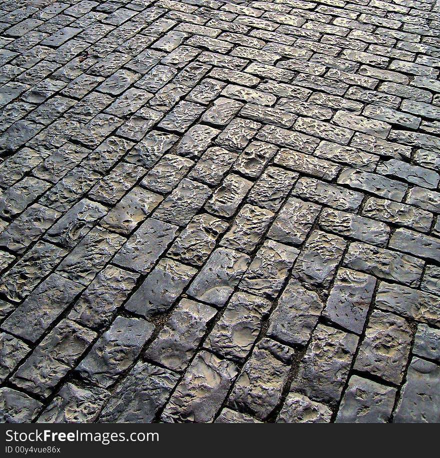 Typical portuguese pavement with the glow of the sun shinning on the surface.