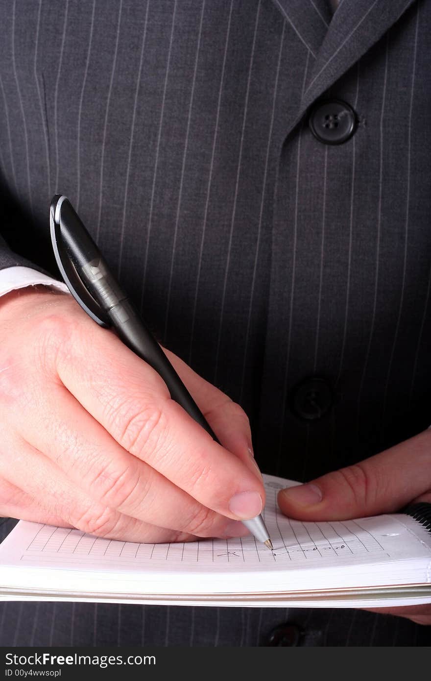 Businessman hand signing paperwork/document or making notes close-up isolated. Businessman hand signing paperwork/document or making notes close-up isolated