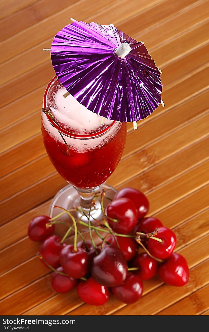 A red cocktail in a glass with cherry and ice. A red cocktail in a glass with cherry and ice